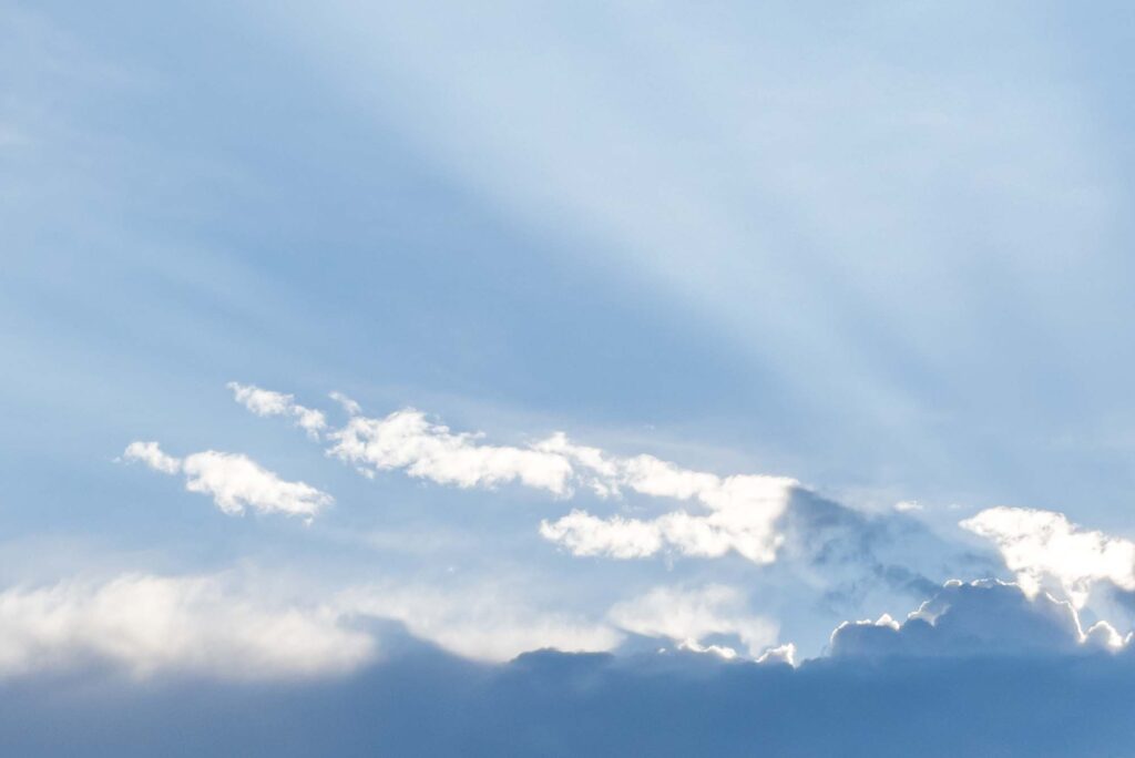 Photograph; Morning sun rays from behind the clouds of a passing shower (after several days of smoky skies)