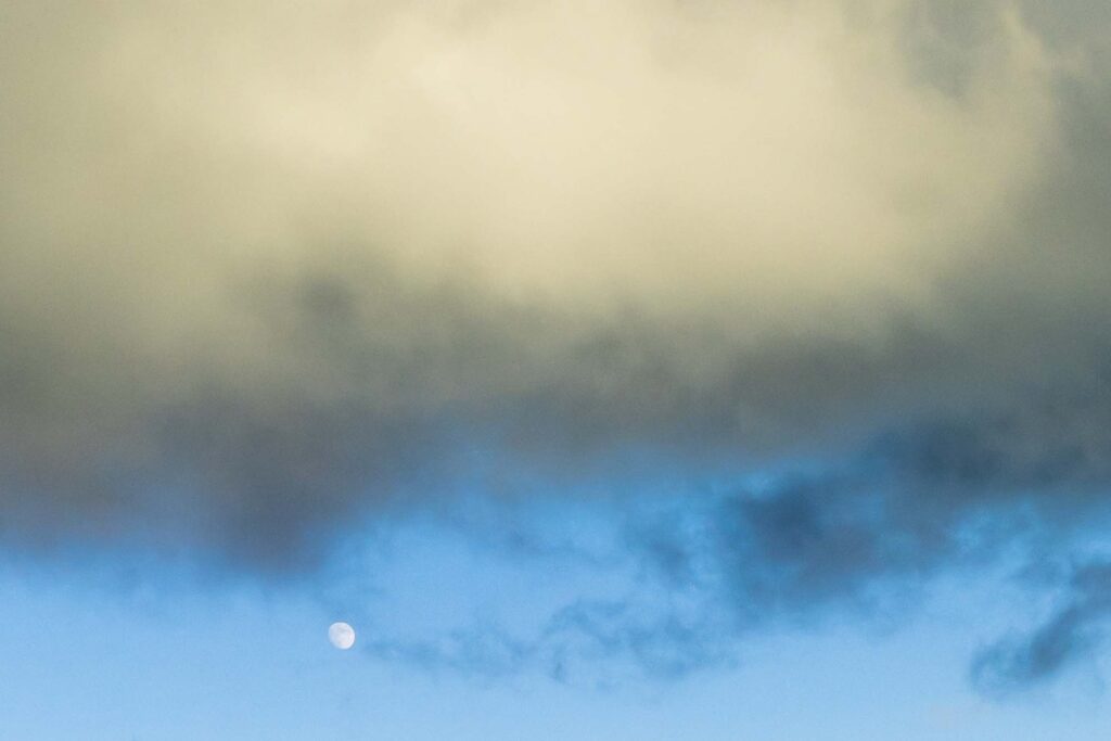 Photograph - A waxing moon below a cloud.