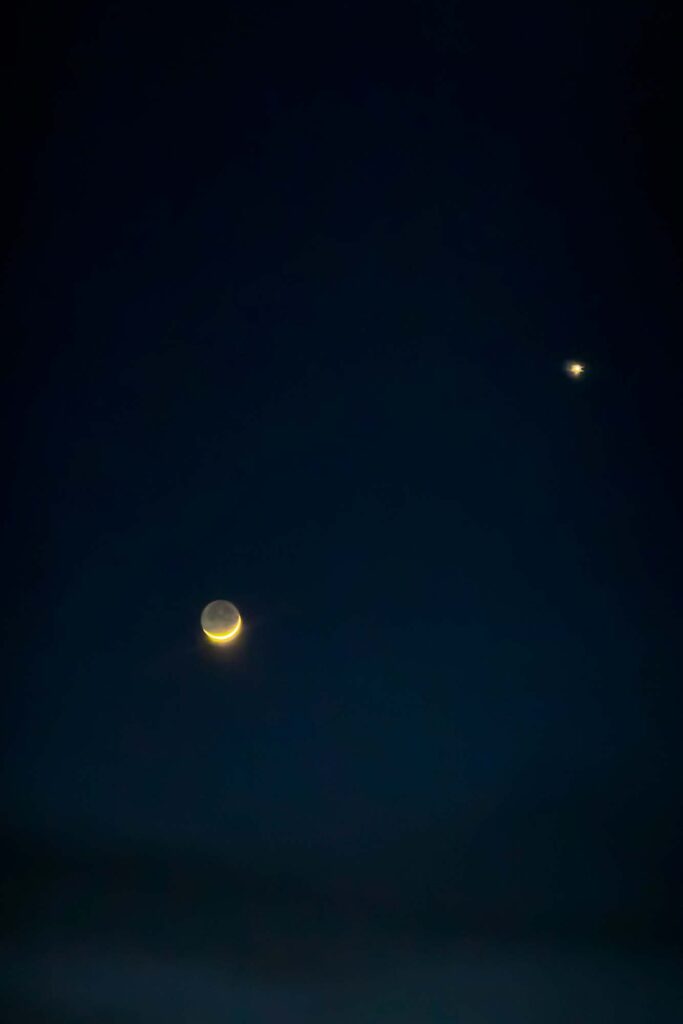 Photograph of the new moon and the in the late dusk.