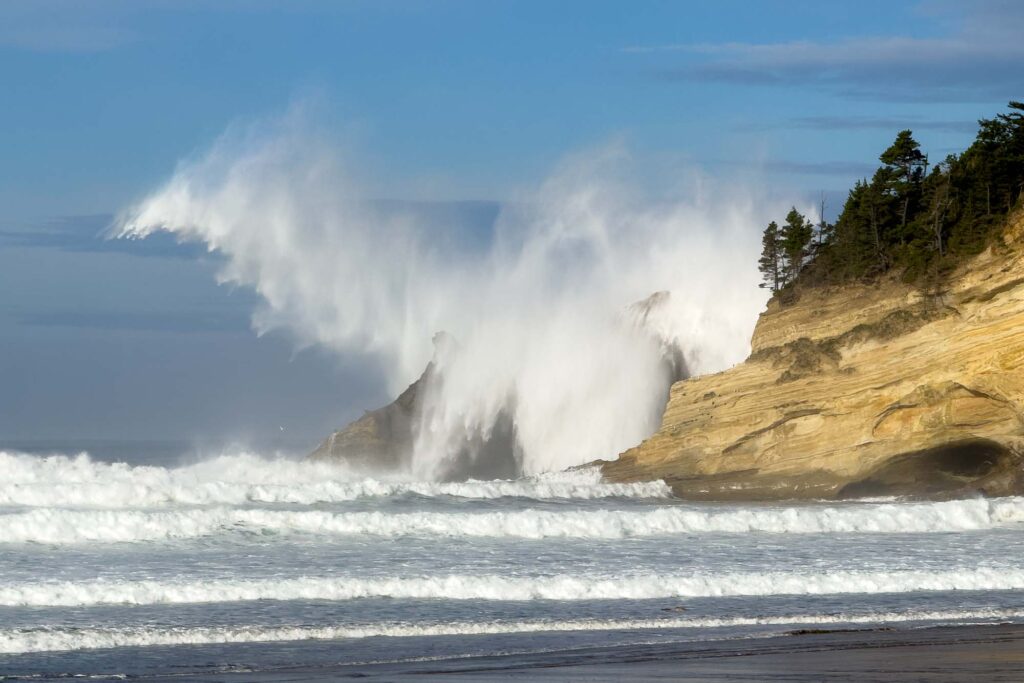 Color photograph of a large wave splashing over Cape Kwanda with the seagull underneath