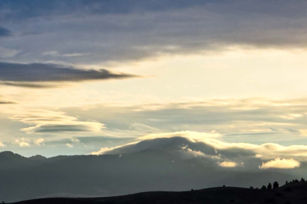Color photograph of clouds blanketing part of Moscow Mountain backlit by the morning sun.